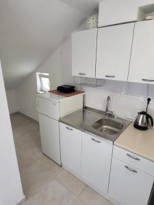 a kitchen with white cabinets and a sink at Apartment Dora in Dubrovnik