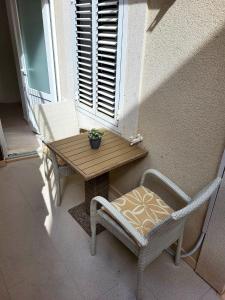 a table and chairs on a porch with a window at Apartment Dora in Dubrovnik