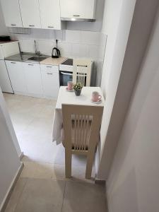 a small white kitchen with a table and chairs at Apartment Dora in Dubrovnik