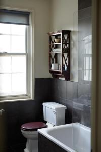 ソールズベリーにあるザ ペンブローク アームズのバスルーム(トイレ、バスタブ付)、窓が備わります。