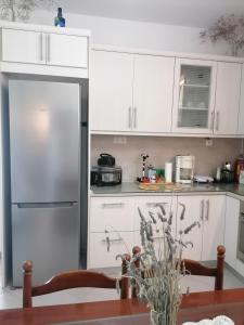 ガラタスにあるTrizinia Viewのキッチン(白いキャビネット、ステンレス製の冷蔵庫付)
