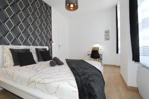 ein Schlafzimmer mit einem weißen Bett mit einem schwarzen Kopfteil in der Unterkunft L'Urbain by EasyEscale in Romilly-sur-Seine