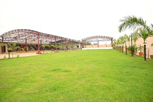 um grande campo verde em frente a um edifício em BASANTA CONVENTION em Balasore