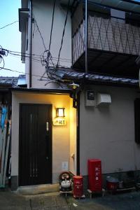 un edificio con una puerta negra y un balcón en 東山の宿 藤屋 en Giommachi