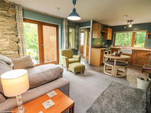 uma sala de estar com um sofá e uma cozinha em Puidrac Cottage em Lochearnhead