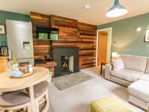 uma sala de estar com uma mesa e uma lareira em Puidrac Cottage em Lochearnhead