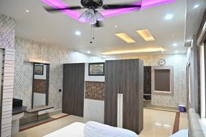 ein Wohnzimmer mit einem Deckenventilator und einem TV in der Unterkunft BASANTA CONVENTION in Balasore