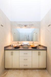 a bathroom with two sinks and a large mirror at VILLA ROA in Roatan