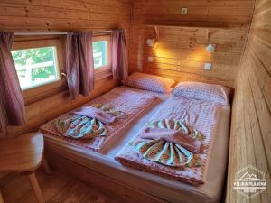 a bedroom with two beds in a log cabin at Chalet Resa - Velika planina in Stahovica