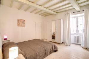 a white bedroom with a bed and a large window at Three Bedroom Apartment Campo dei Fiori in Rome