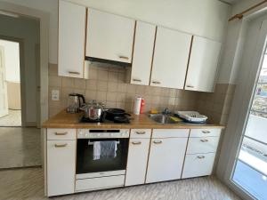 a kitchen with white cabinets and a sink at Heart of Basel, Beautiful Guest House in Basel