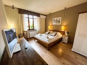 a bedroom with a bed and a flat screen tv at Villa Filmowiec in Polanica-Zdrój