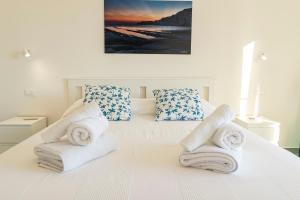 ein Schlafzimmer mit einem weißen Bett mit Handtüchern darauf in der Unterkunft Sulla Valle in Agrigento