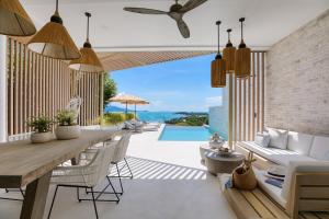 a dining room with a table and chairs and a pool at BEACHSIDE VILLA - CLOUD 9 - at BAYSIDE LUXURY VILLAS Samrong Bay Beach, 3 BED 4 BATH, SALT WATER POOL, SEA and SUNSET VIEWS, only 200m walk to the Beach in Amphoe Koh Samui