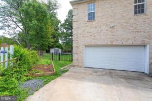 a brick house with a white garage door at Brand New, Cozy, Modern, One-bedroom Apartment in Falls Church