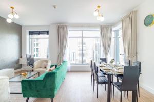 een woonkamer met een tafel en een groene bank bij Full Marina View Luxury 2BR - Park Island Sanibel in Dubai