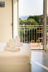 ein weißes Bett in einem Zimmer mit einem großen Fenster in der Unterkunft Sulla Valle in Agrigento