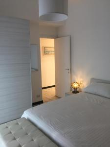 een witte slaapkamer met een wit bed en een lamp bij ca Debora Apartment in Rapallo