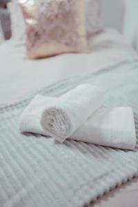 einen Stapel Handtücher auf dem Bett in der Unterkunft Bv Luxury Apartment Penthouse Conditioning House in Bradford