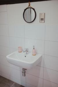 ein weißes Badezimmer mit einem Waschbecken und einem Spiegel in der Unterkunft Bv Luxury Apartment Penthouse Conditioning House in Bradford