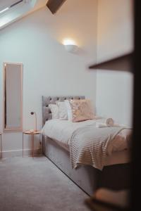 ein Schlafzimmer mit einem großen Bett mit weißer Bettwäsche und Kissen in der Unterkunft Bv Luxury Apartment Penthouse Conditioning House in Bradford