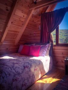 Bett in einem Blockhaus mit Fenster in der Unterkunft Blue Village 8 in Kolašin