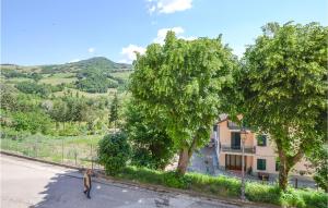 un hombre caminando por una calle junto a los árboles en Lovely Apartment In Monte Cerignone With Kitchen, en Monte Cerignone