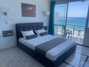 1 dormitorio con 1 cama y balcón con vistas al océano en Julies Studios en La Canea