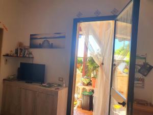a living room with a television and a sliding glass door at Salento - A Casa di Lilli in Porto Cesareo