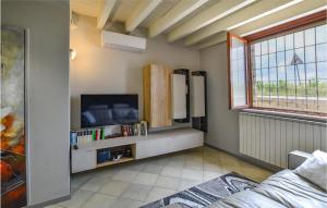 een woonkamer met een flatscreen-tv en een koelkast bij Lovely Apartment In Pozzolengo With Kitchenette in Pozzolengo