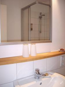 a bathroom with a sink with a mirror and a shower at Hotel 26 in Berlin