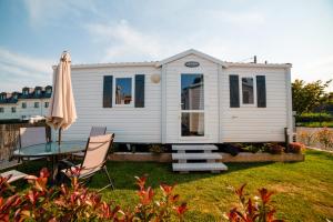 a white tiny house with a table and a patio at Remanso do Mar en O Grove in O Grove