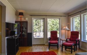 uma sala de estar com duas cadeiras e uma televisão em 4 Bedroom Lovely Home In Mariefred em Mariefred