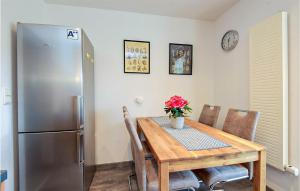 cocina con mesa y nevera de acero inoxidable en Beautiful Apartment In Zella-mehlis With Wifi en Zella-Mehlis