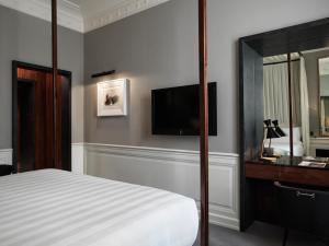 a bedroom with a bed and a flat screen tv at J.K. Place Roma - The Leading Hotels of the World in Rome