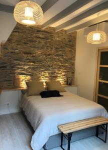 a bedroom with a bed and a stone wall at La Maison du Cocher - Studio climatisé en Hypercentre in Angers