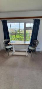 um quarto com uma mesa e duas cadeiras e uma janela em Beautiful 1 bedroom cottage with courtyard. em Kent