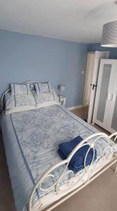 a large bed in a bedroom with blue walls at Beautiful 1 bedroom cottage with courtyard. in Kent