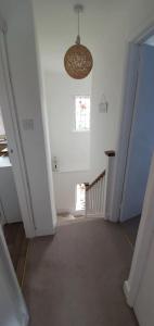 an empty room with a hallway with a chandelier at Beautiful 1 bedroom cottage with courtyard. in Kent