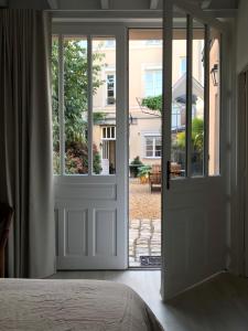 a bedroom with a door leading to a yard at La Maison du Cocher - Studio climatisé en Hypercentre in Angers