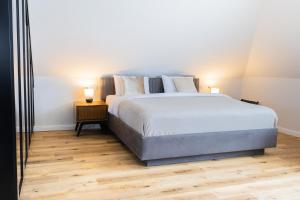 a bedroom with a large bed and a wooden floor at Strandnahe & hochwertige Ferienunterkunft, mit Gartenzugang, Parkplatz und Fahrradunterstellplatz in Scharbeutz