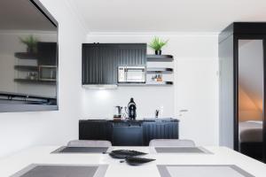 a kitchen with white walls and a black and white kitchen at Strandnahe & hochwertige Ferienunterkunft, mit Gartenzugang, Parkplatz und Fahrradunterstellplatz in Scharbeutz
