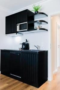 a black kitchen with a black counter top at Strandnahe & hochwertige Ferienunterkunft, mit Gartenzugang, Parkplatz und Fahrradunterstellplatz in Scharbeutz +16 photos