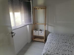 um pequeno quarto com uma cama e uma janela em Lourisol em Lourinhã