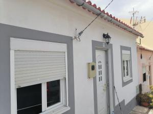 a white house with a door and a window at Lourisol in Lourinhã