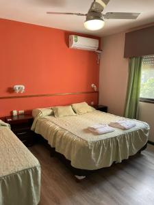 a bedroom with two beds and a red wall at Hotel Algarrobo in Merlo