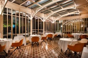 グリニャンにあるLe Clair de la Plume - Teritoriaの白いテーブルと椅子、窓のあるレストラン