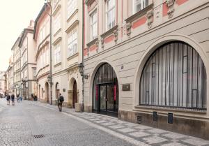 een lege straat met mensen die door een straat lopen bij Opitzův dům in Praag