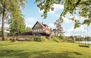 una casa negra en una colina con un patio en Beautiful Home In rkelljunga With House Sea View, en Orkelljunga