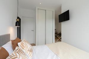 a bedroom with a bed with a television on the wall at Cabañas Alcobas do Sil Ecoturismo in Parada del Sil